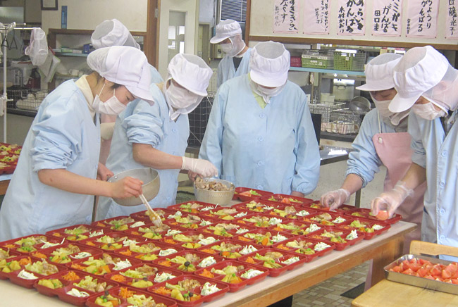 弁当の盛りつけ作業風景（障害のある方の日中活動として仕事をしている一コマ）